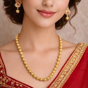 Woman wearing single golden Ekdani necklace set with matching earrings by Lumera